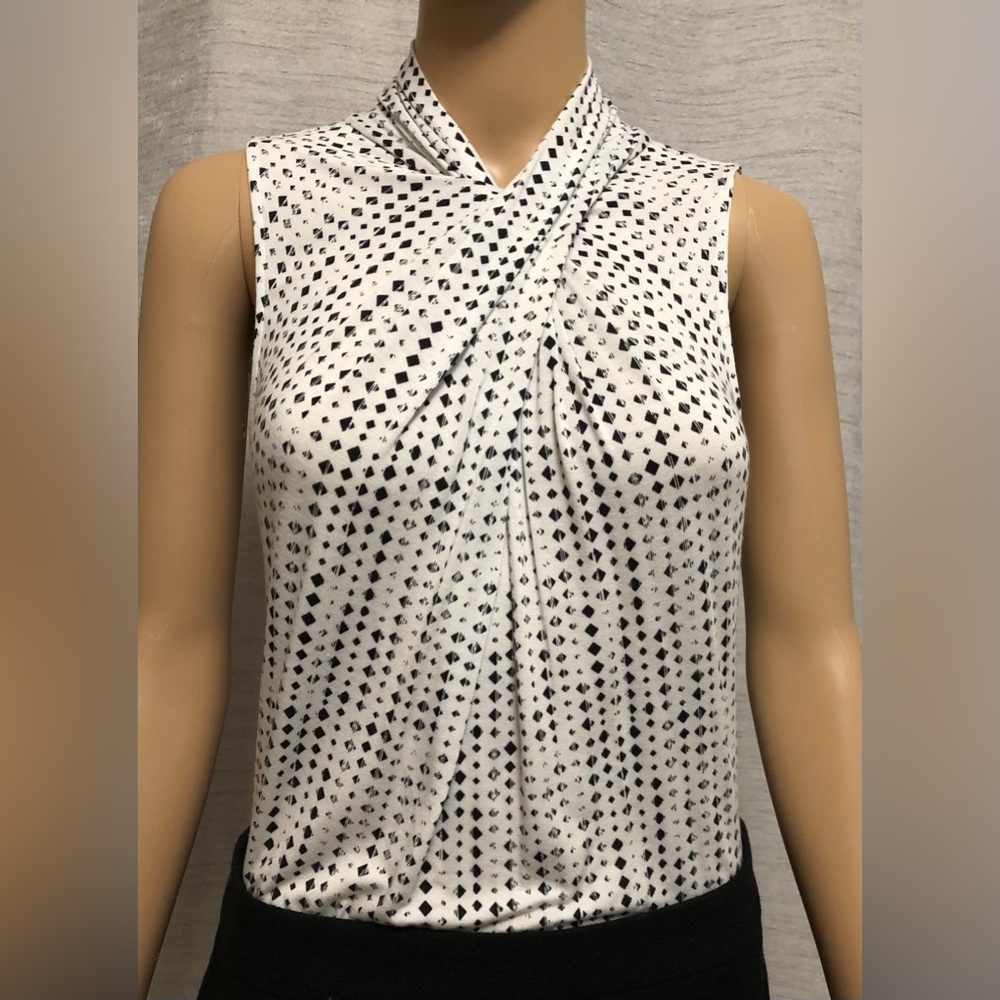 Black and white Worthington sleeveless blouse with button up neck in back.